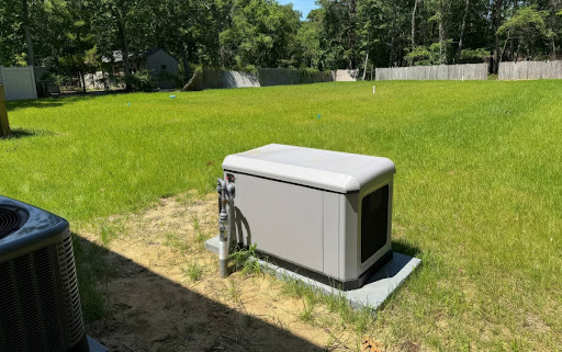 A standby generator installed outside in the backyard of a home.